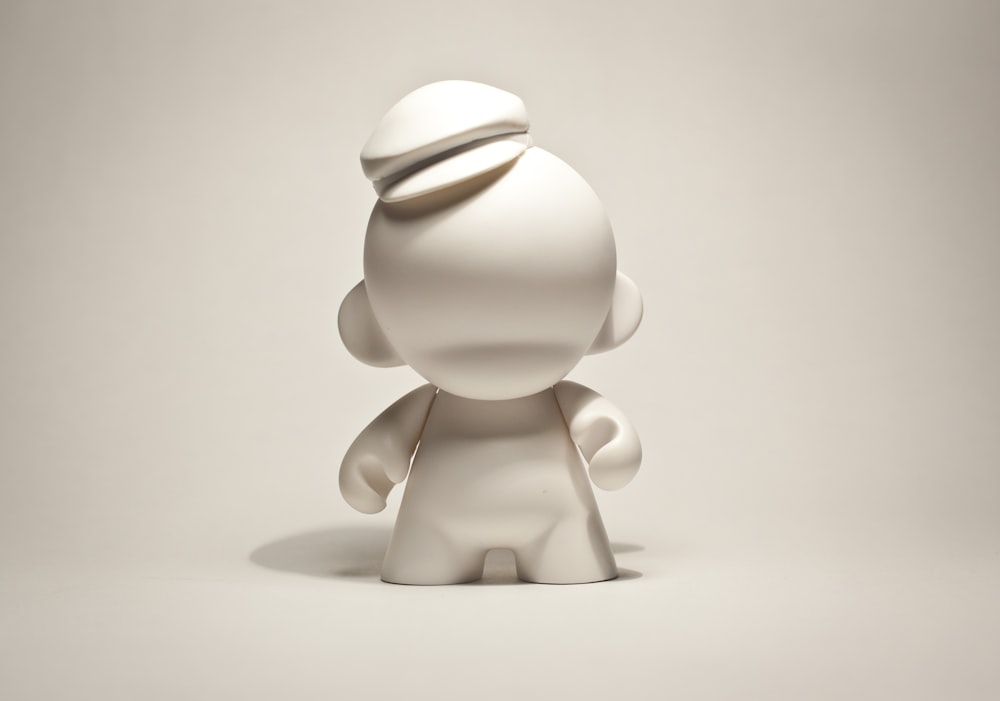 Una escultura blanca de una persona con un sombrero en la cabeza