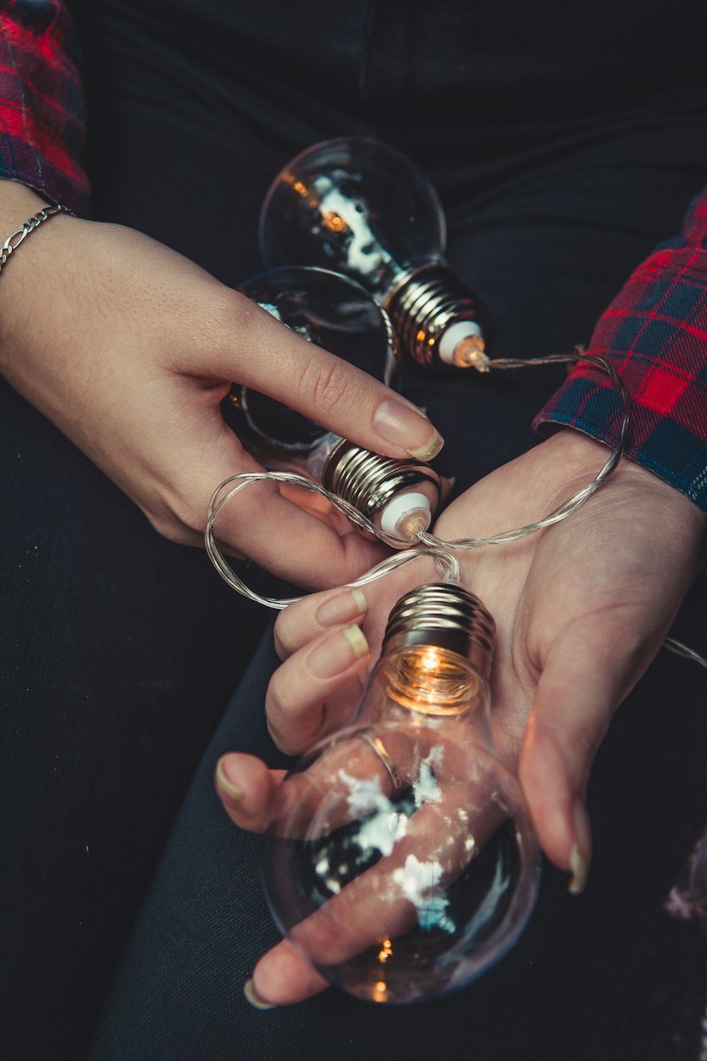 person holding three lightbulbs