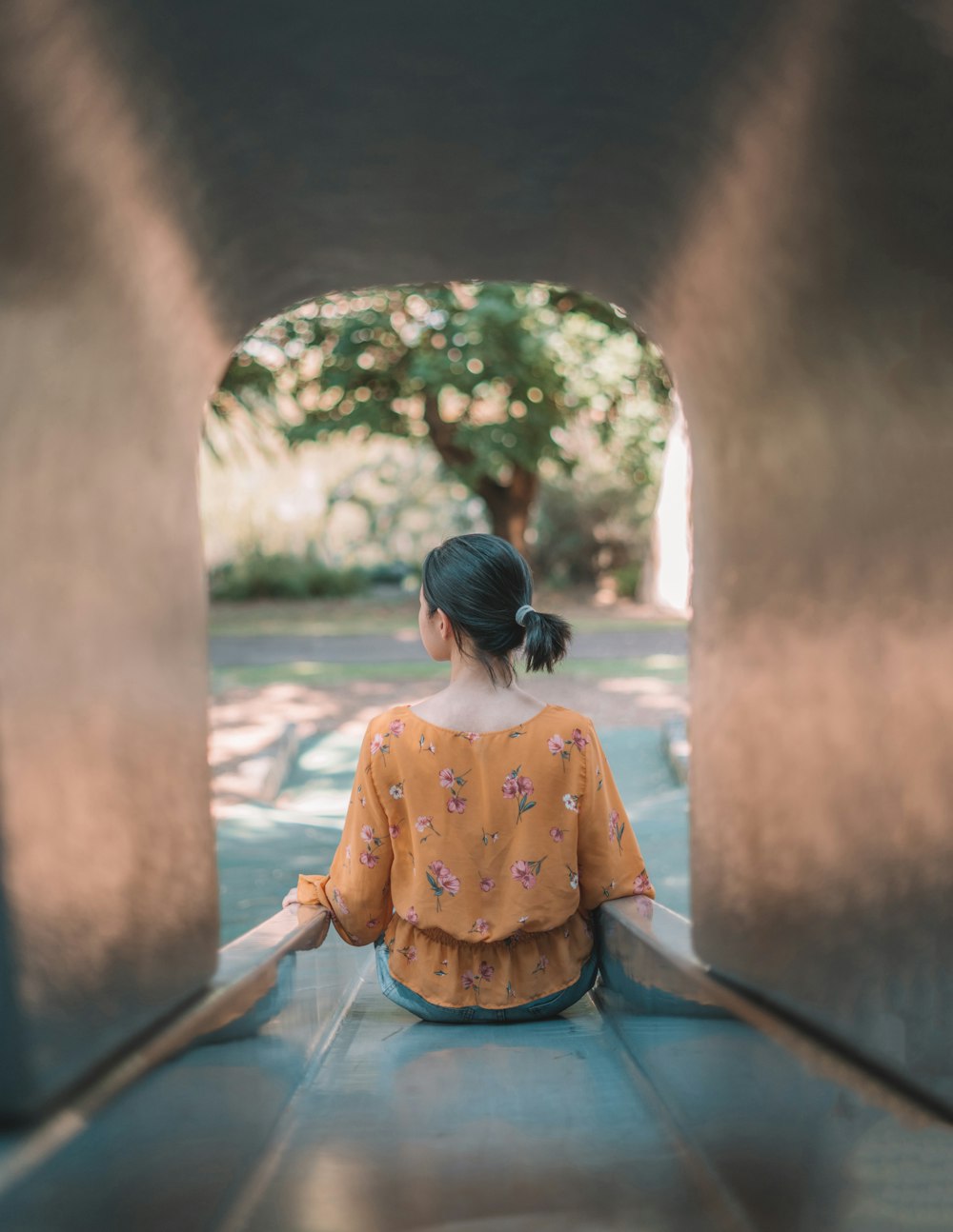 woman wearing yellow floral blouse sitting on slide