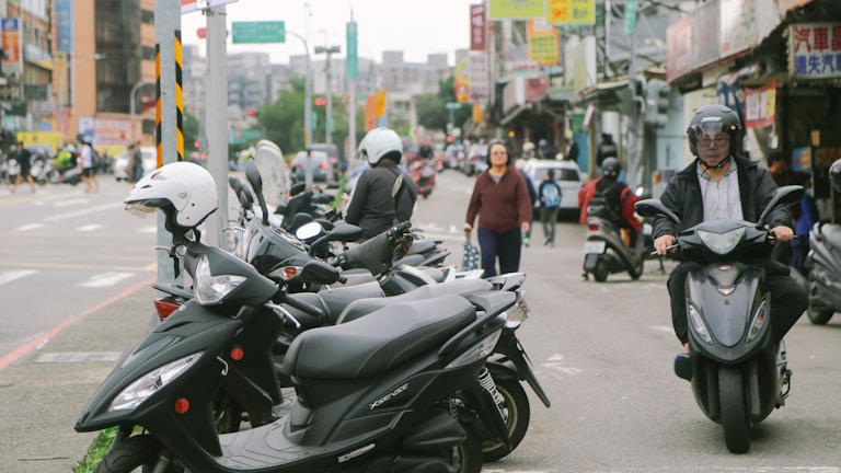A bustling city street with agile commuters using electric scooters.