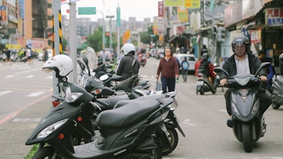 A vibrant city street with people riding electric scooters, showcasing urban mobility.