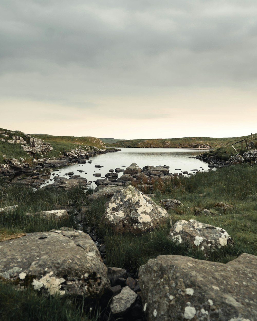 aerial photography of rock formations near body of water under white and gray sky