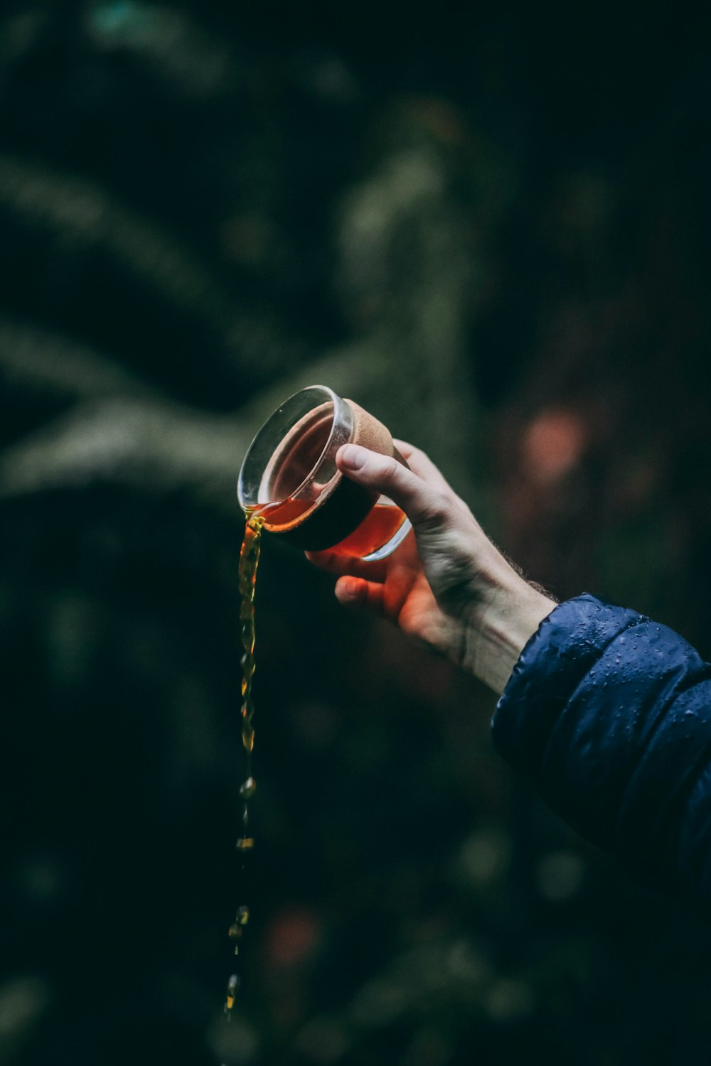 person pouring yellow liquid from cup