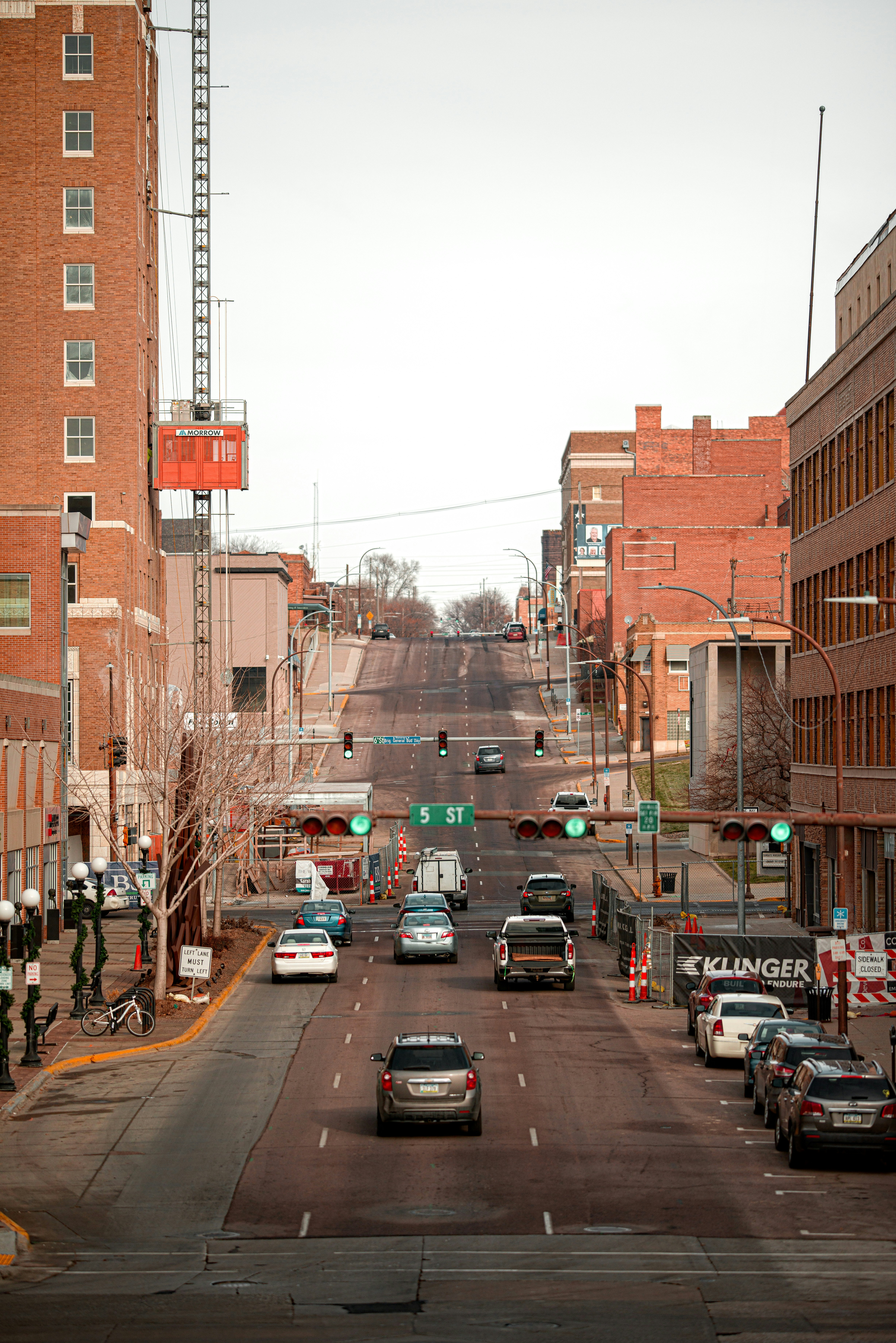 cars on road between buildings during daytime