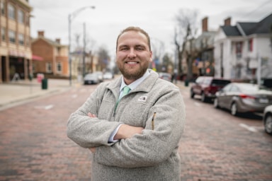 photography poses for men,how to photograph professional headshot of smiling male ; man wearing grey jacket