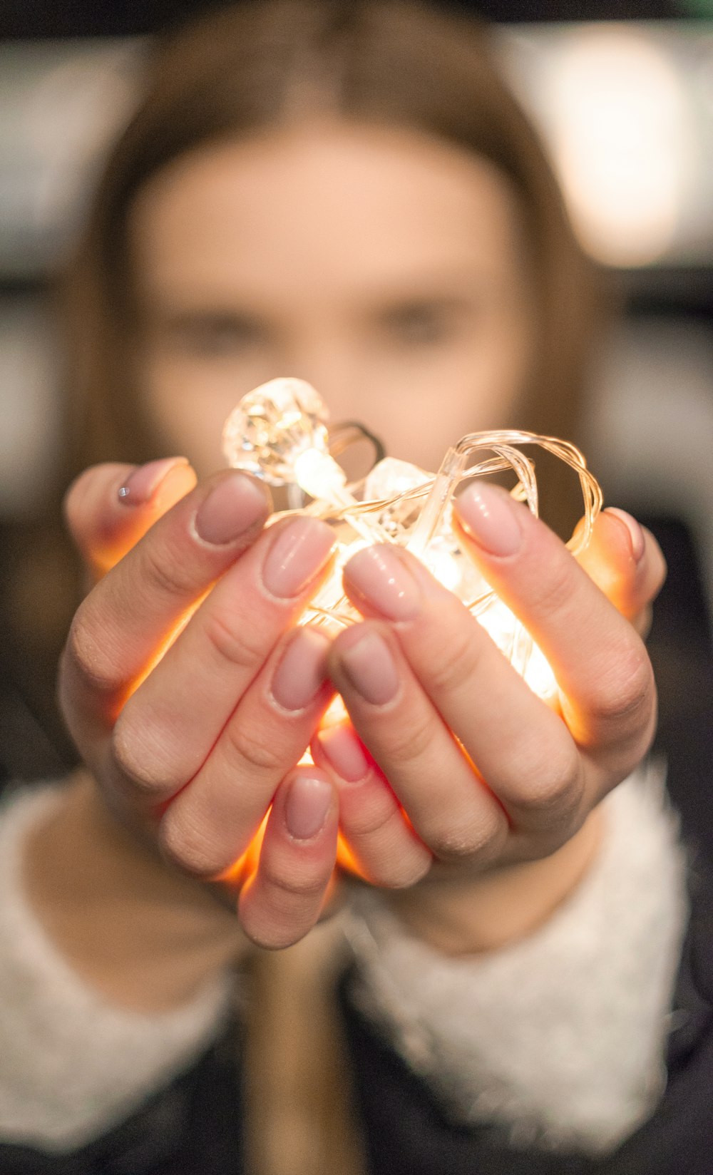 woman holding string lights