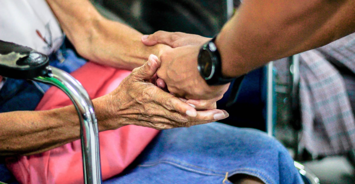 man holding hand with woman on chair