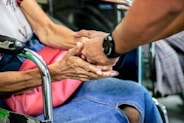 man holding hand with woman on chair