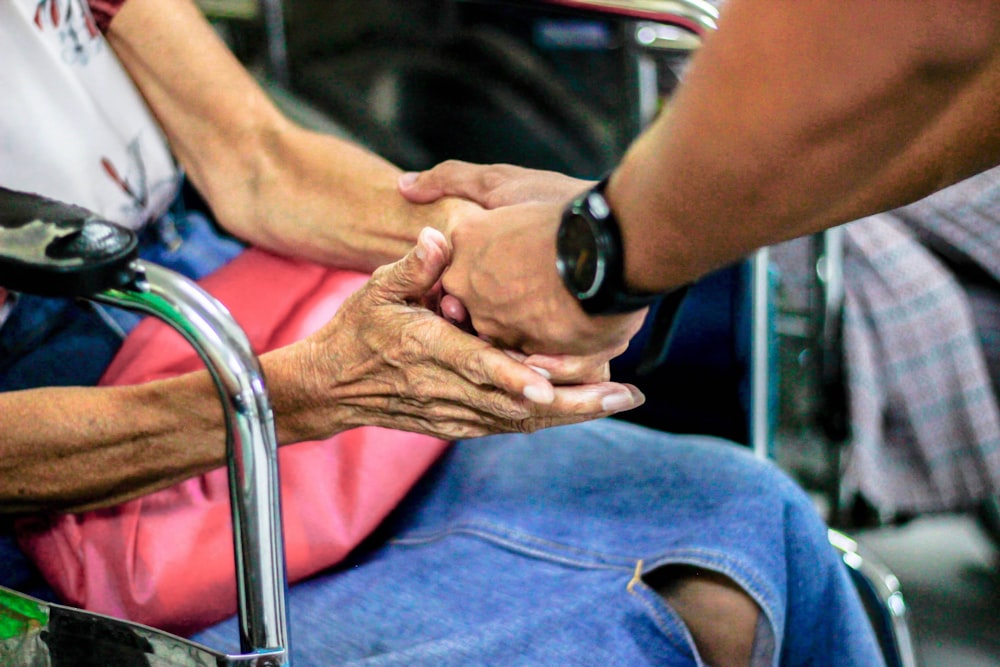 hombre de la mano con mujer en la silla