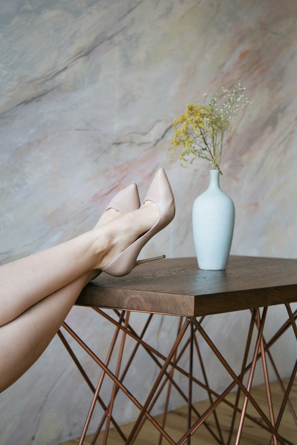 person leaning on brown wooden table with flower atop