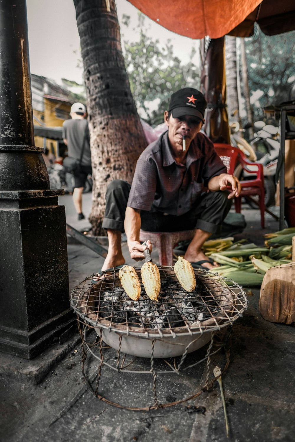 man grilling corns on firepit