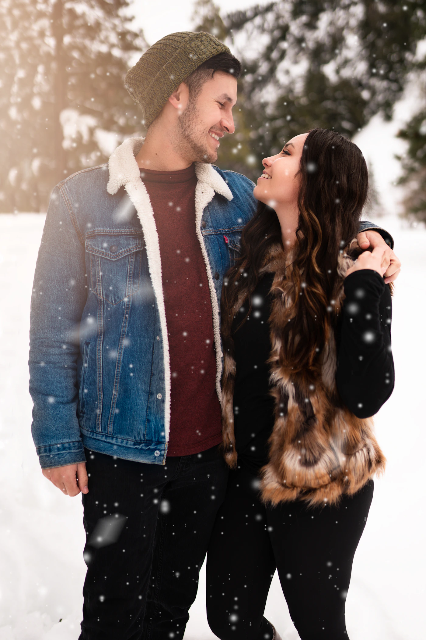 Couple holding each other close in a warm embrace standing together in fresh white winter snow