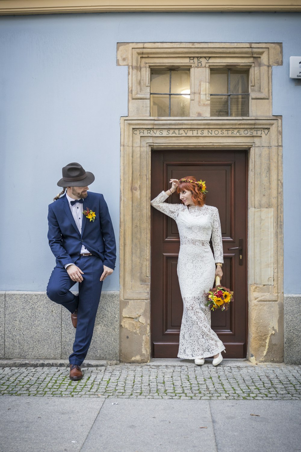 man leaning back on wall beside woman standing beside closed door