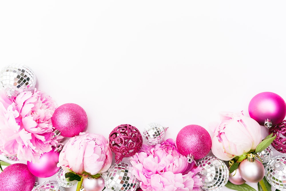 palline rosa accanto ai fiori dai petali rosa