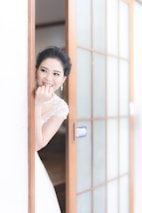 A bride glowing with flawless makeup, smiling gently in a softly lit room.