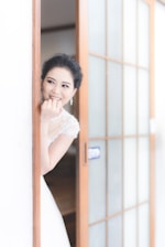 Bride smiling peacefully while planning her wedding with a consultant in a cozy, light-filled room.
