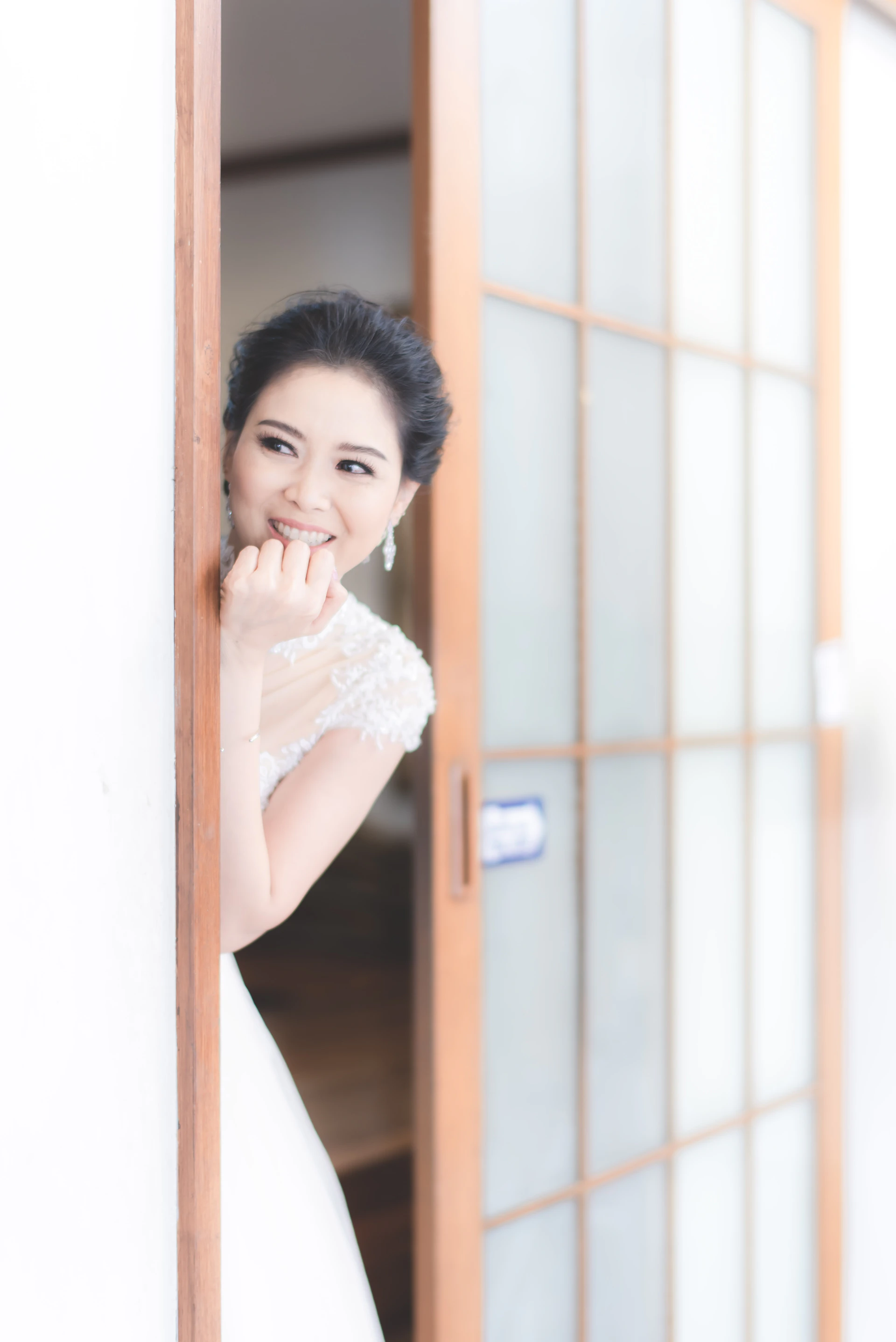 A calm bride smiling while organizing her wedding plans on a tablet, surrounded by light, airy decor.