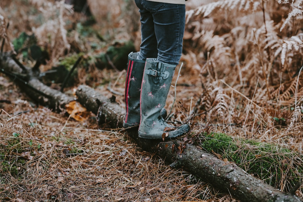 a person standing on a log in the woods