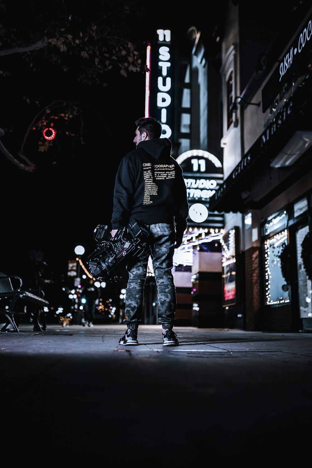 low-angle photography of man standing outside a building during nighttime