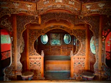 Traditional Kashmiri wooden carvings decorating the walls of the houseboat room.