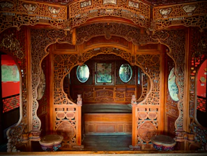 Traditional Kashmiri wooden carvings decorating the walls of the houseboat room.