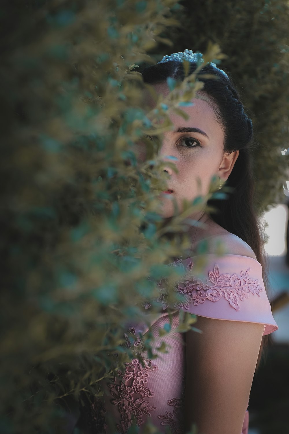 woman wearing pink dress standing near rosemary plant