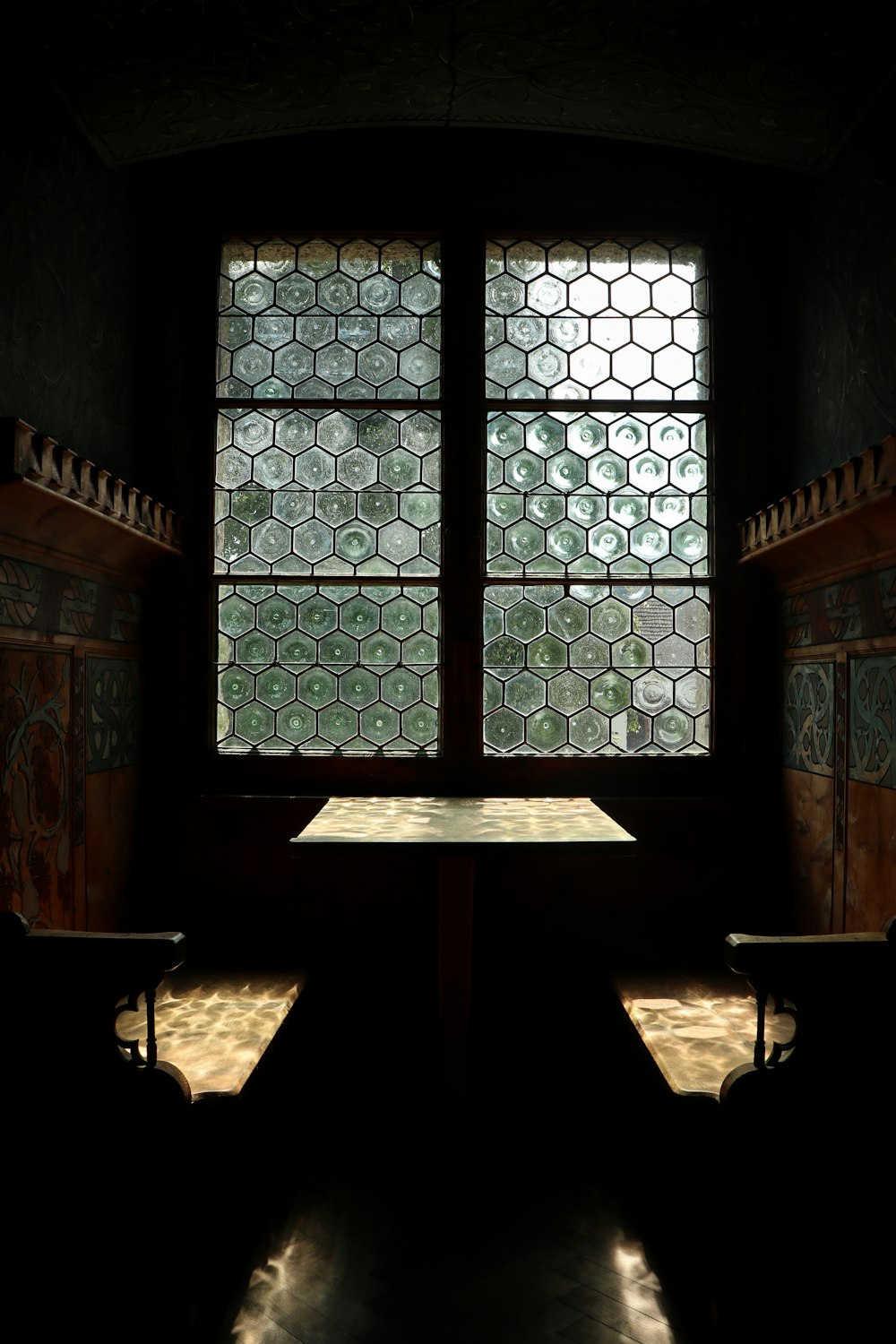 a table and two benches in front of a window