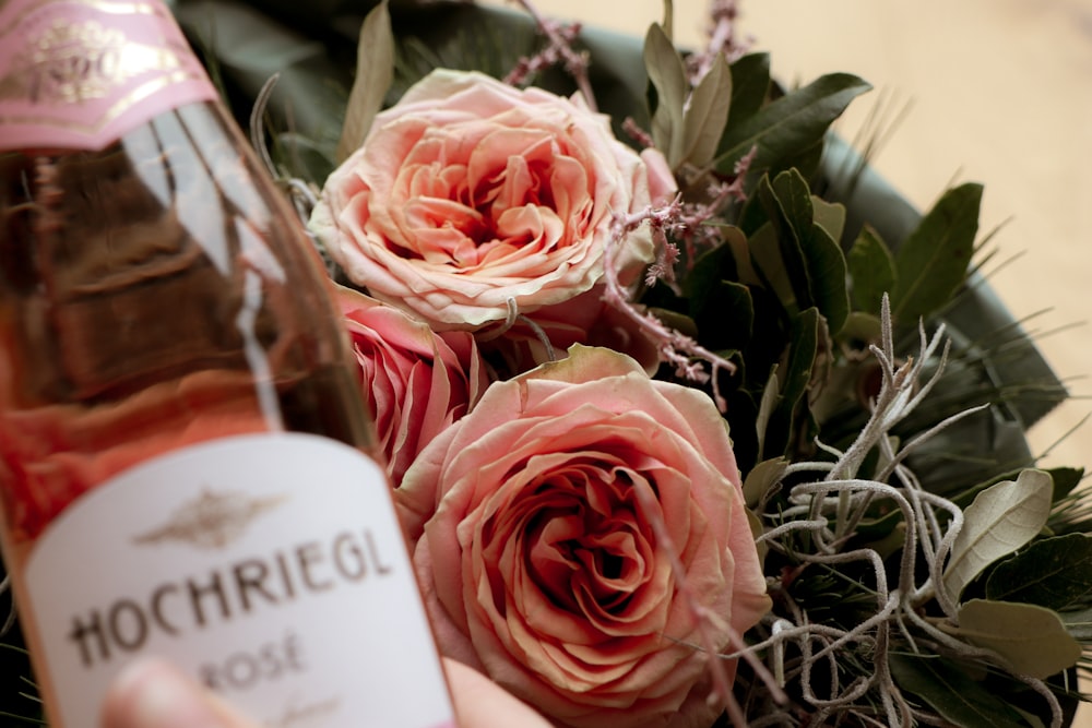 Hochriegl rose bottle beside white rose flowers