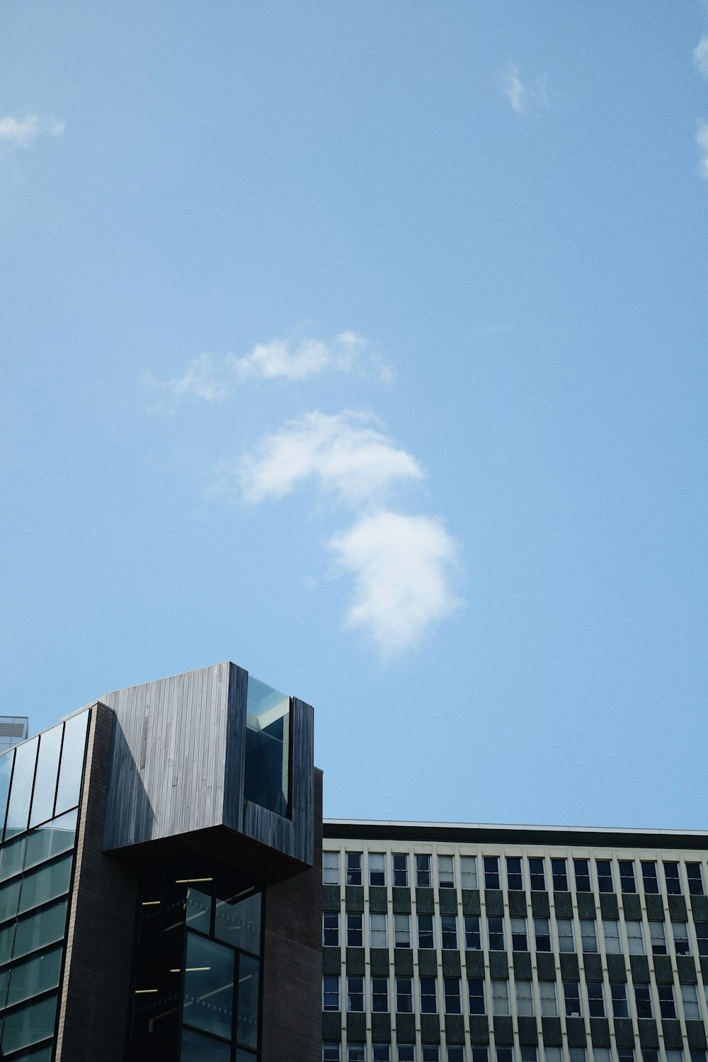 low-angle photography of a high-rise building under a calm blue sky