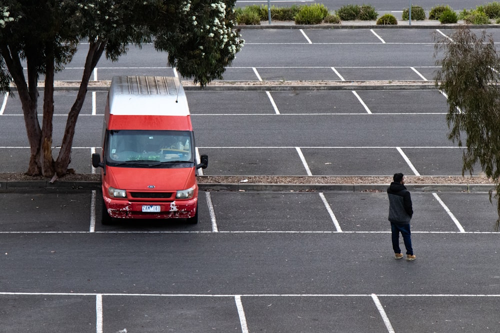 person standing near parked van at parking lot during daytime