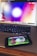A smartphone displaying an app or game with cartoonish characters and greenery is resting on a laptop keyboard. The laptop screen shows a blurred, colorful background with a circular design.