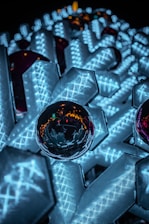 Close-up of glowing 3D geometric shapes blending into a dark background.