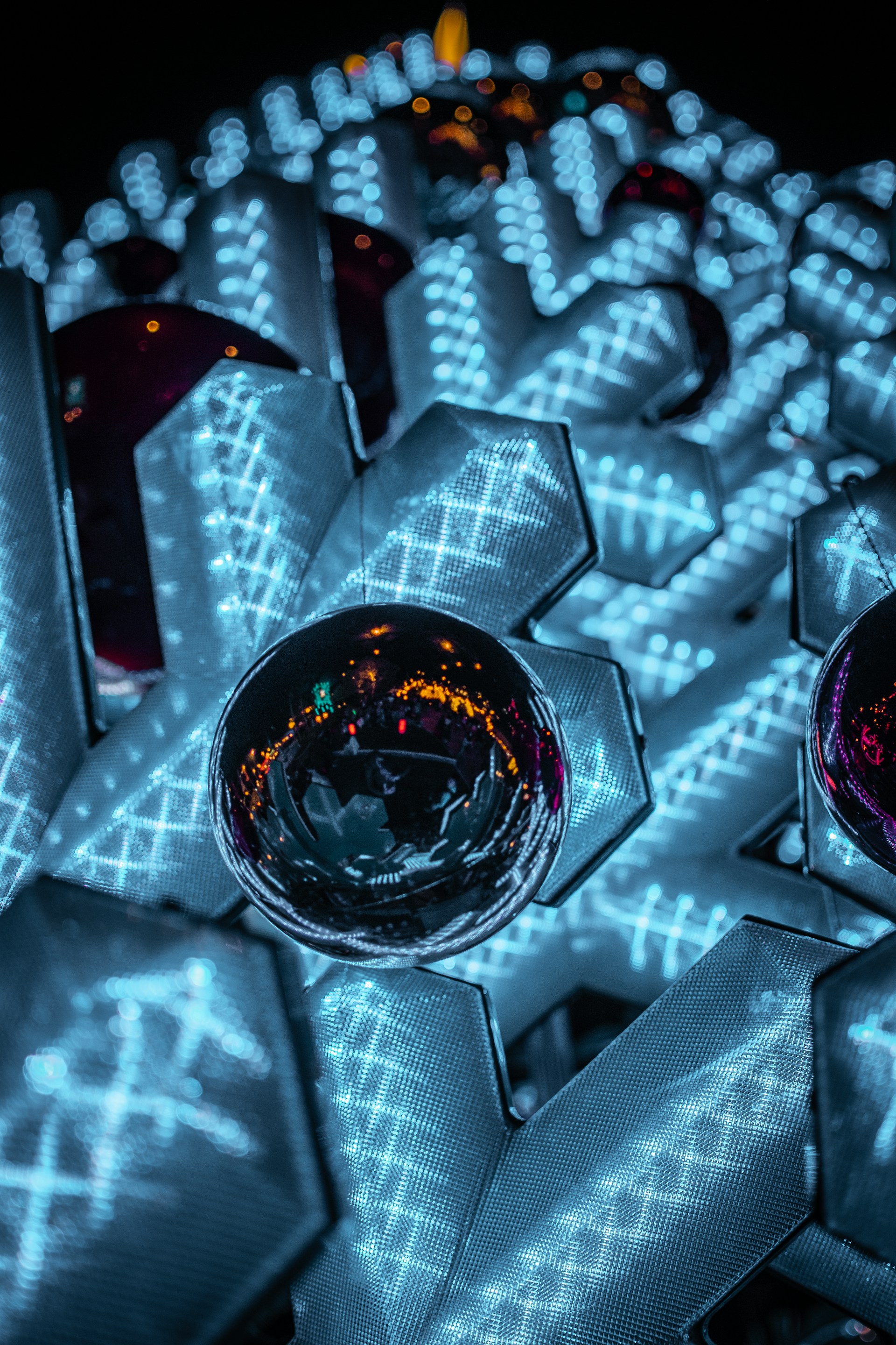 A vivid close-up of a twisting geometric shape illuminated by shifting dynamic lights, showcasing multi-axis rotation and depth.