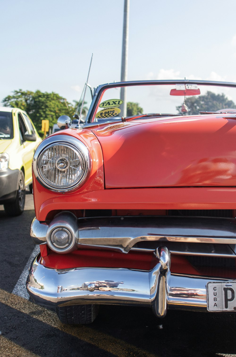 a red car parked in a parking lot next to other cars