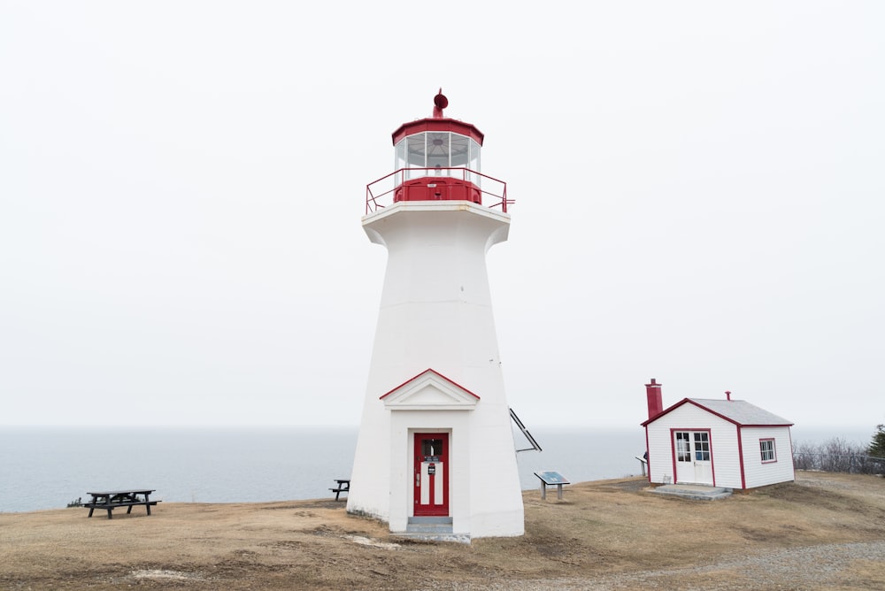 white lighthouse near shed