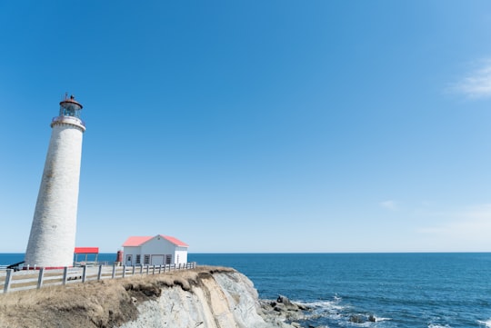 lighthouse near house in Cap-des-Rosiers Lighthouse Canada