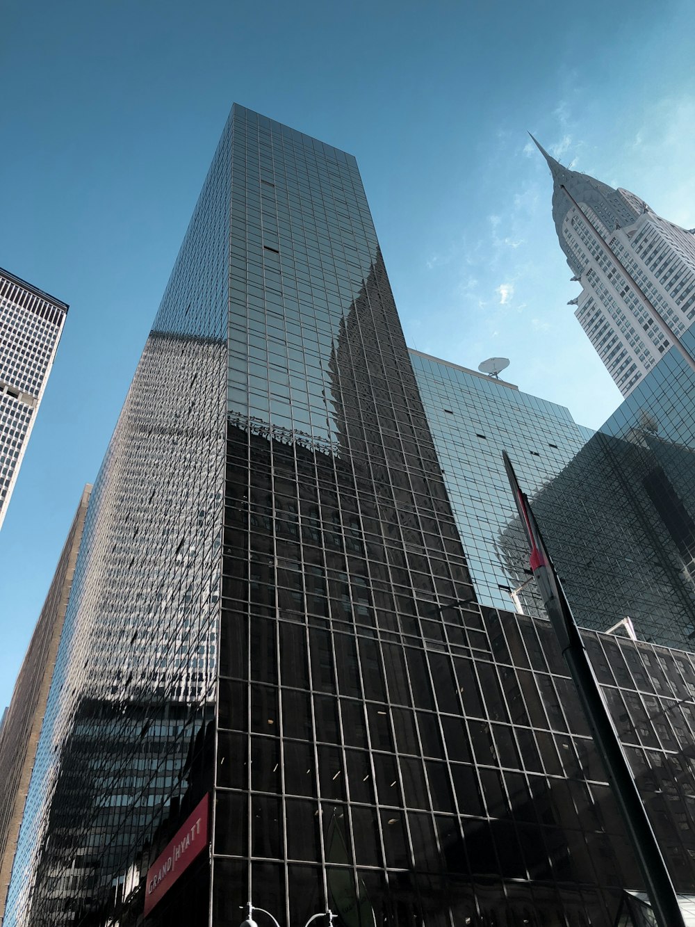 low-angle photography of black glass high-rise building under a calm blue sky