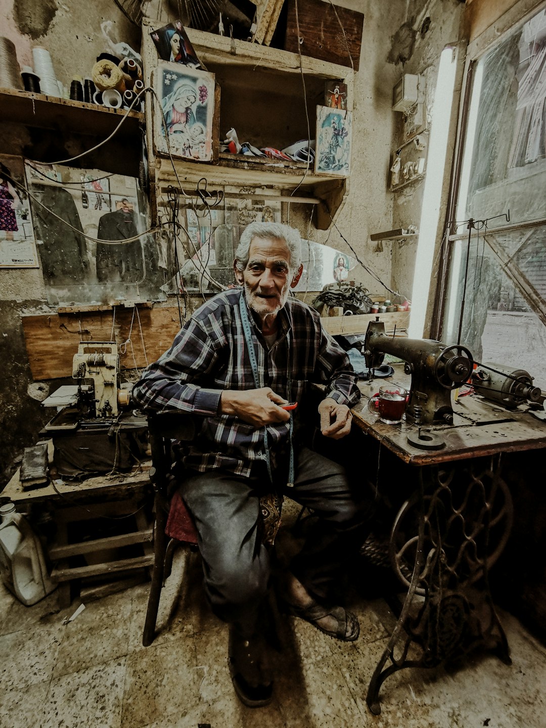 sitting man beside sewing machine