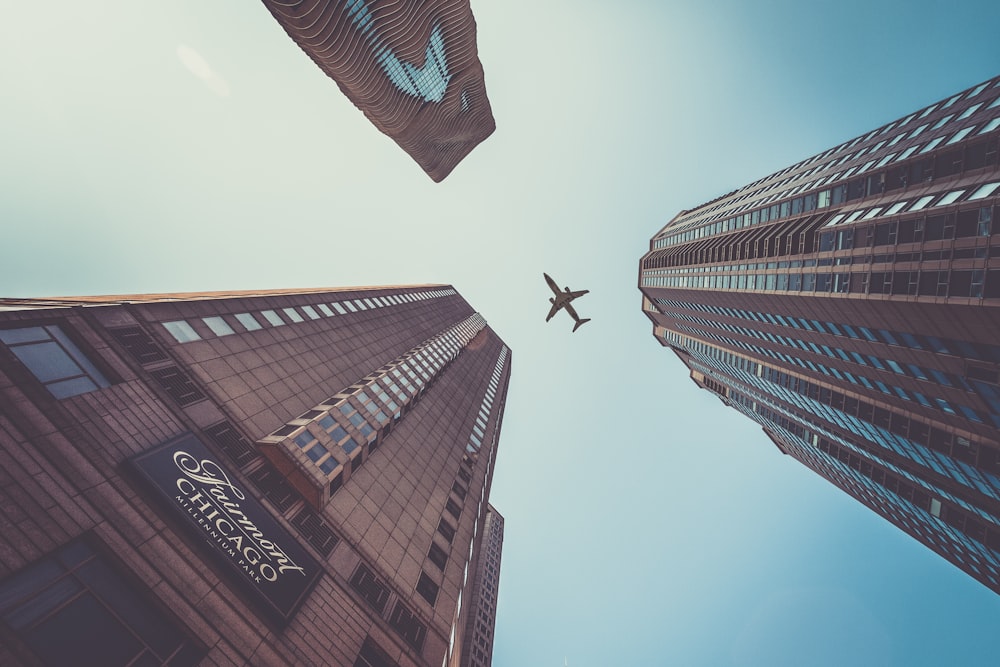 flying airplane above high-rise buildings