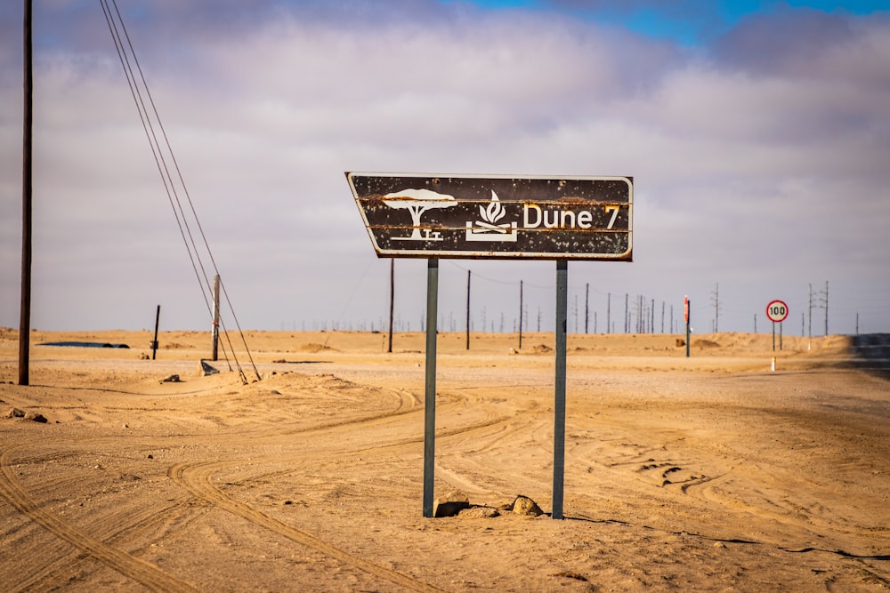 Dune 7 sign on desert under white and blue sky