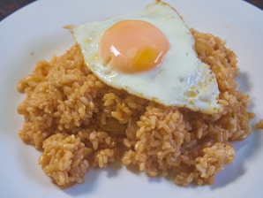 A vibrant plate of Nasi Goreng topped with fried egg.