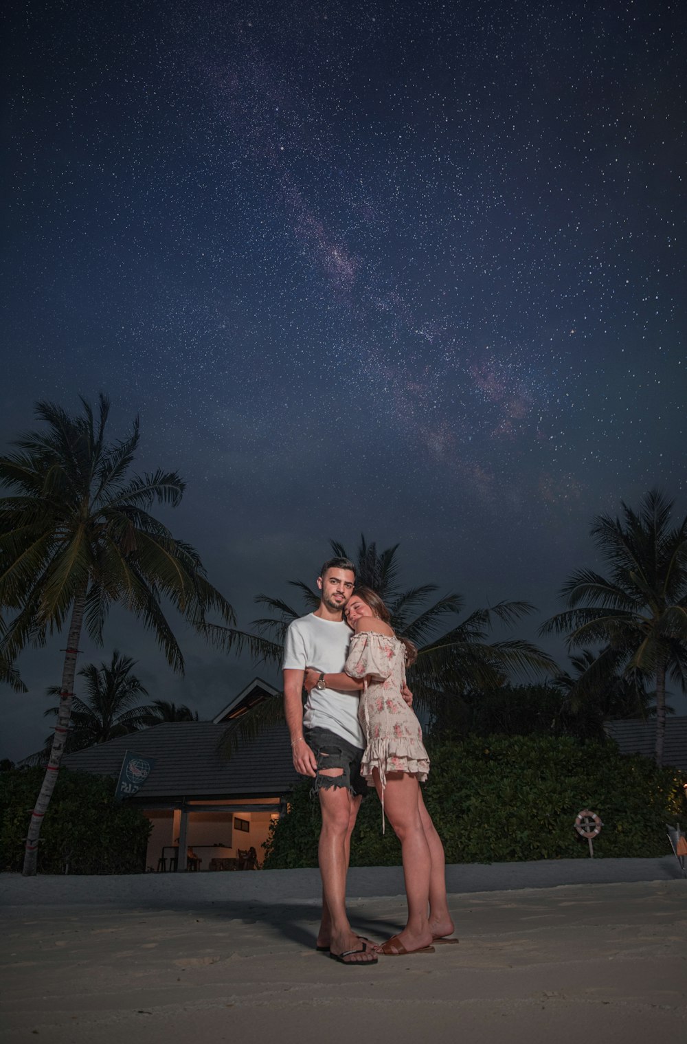 couple hugging near coconut trees