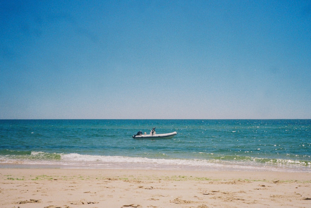 white and black boat on body of water during daytime