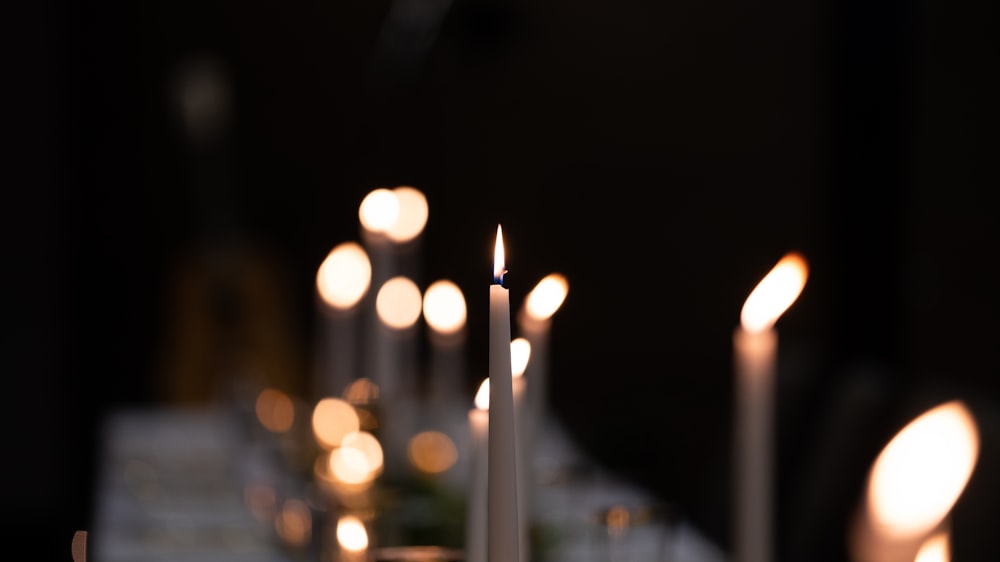 shallow focus photo of lighted white candle