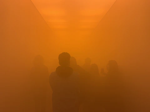 A high-end commercial lobby engulfed in thick yellow-hued fog as intruders are disoriented.