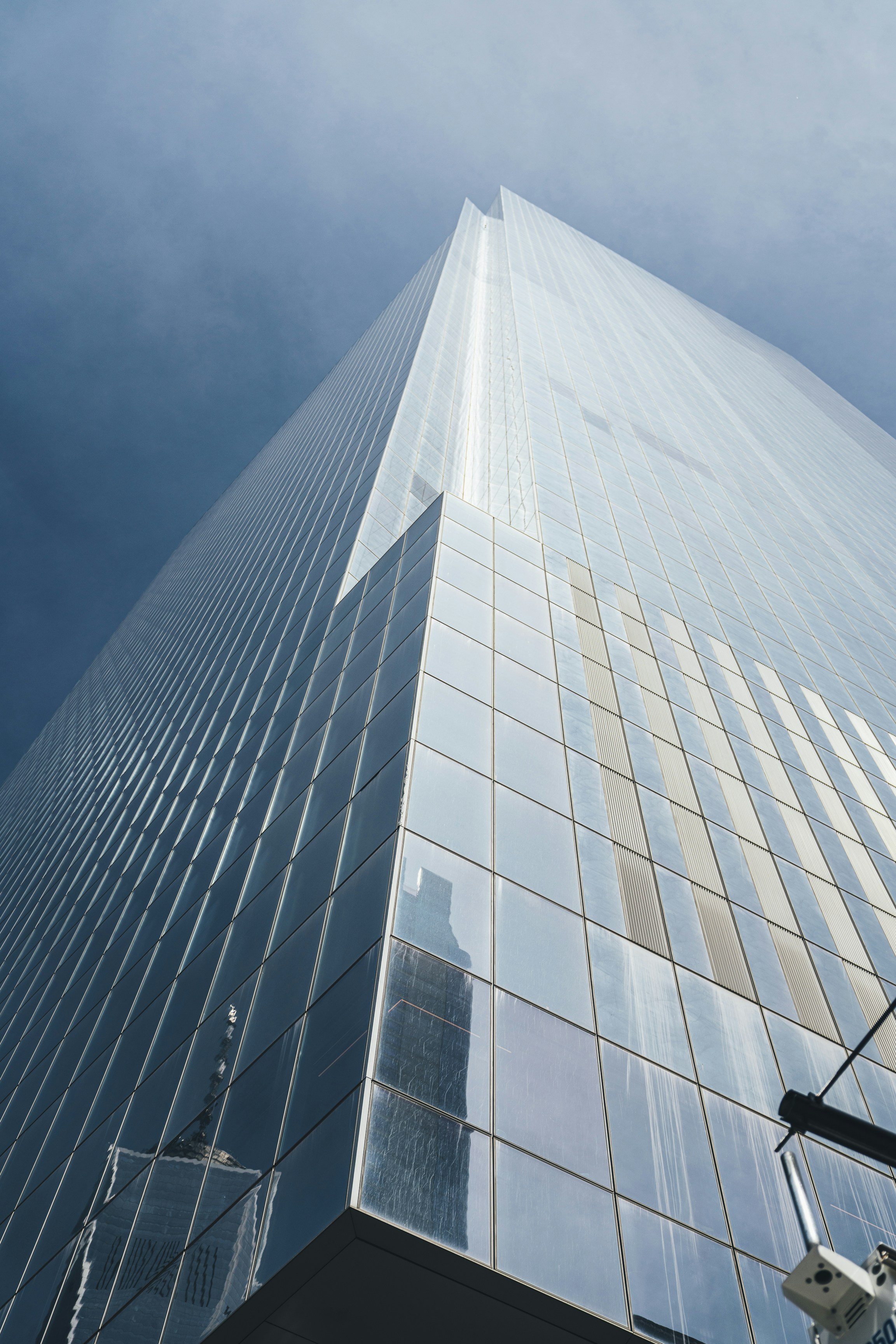 low-angle photography of blue glass high-rise building under a calm blue sky