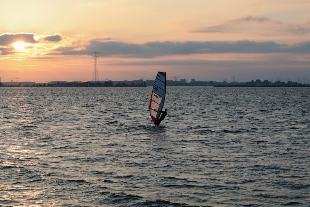 man sailing a boat in the sea during golden hour