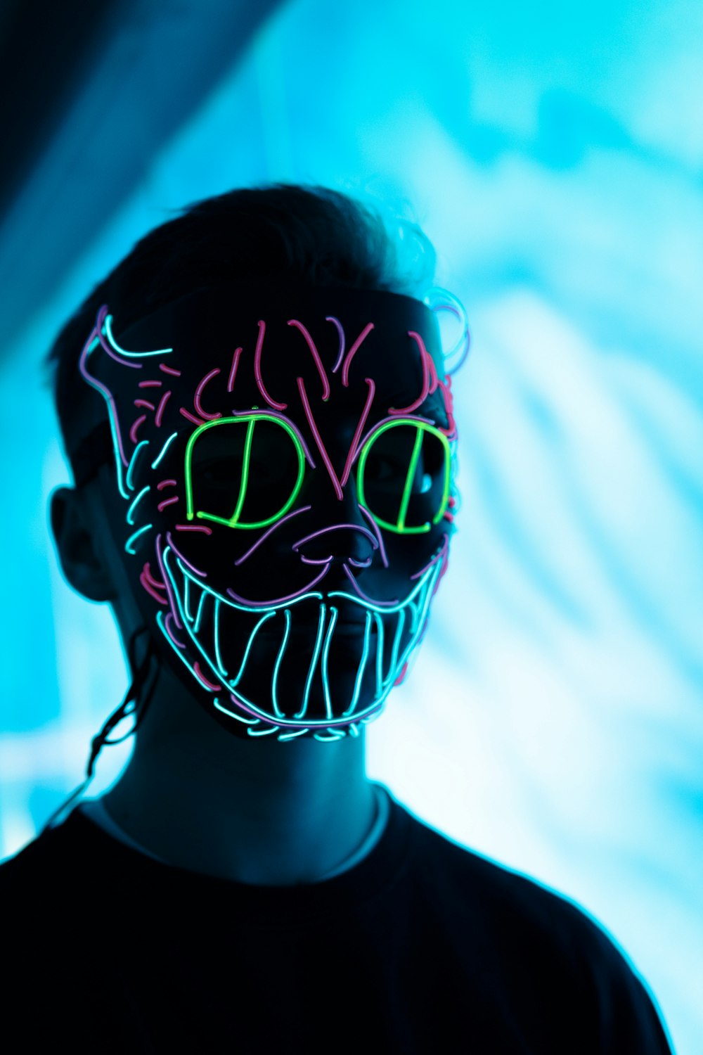 man wearing green and red cat neon mask