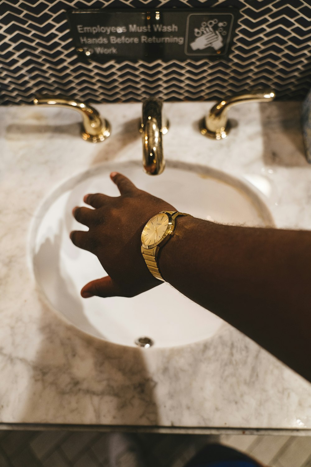 person about to hold faucet in a sink