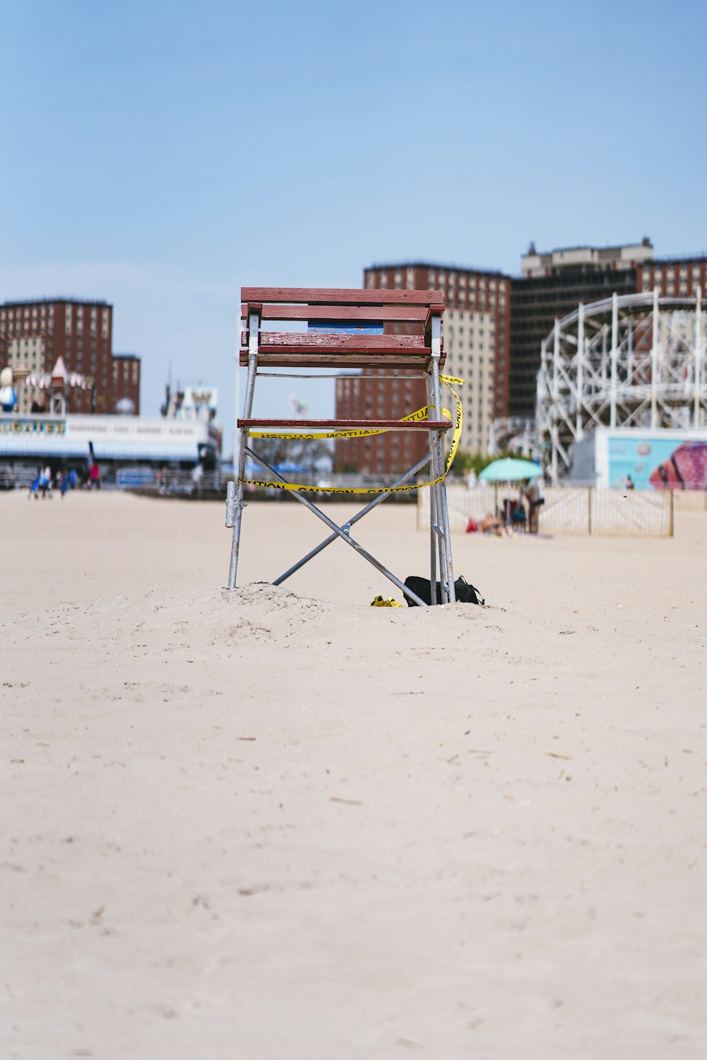 a wooden chair sitting on top of a sandy beach